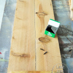 Lake Girl Paints fence boards before